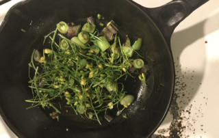 Sauteed arugula bloom stalks and sugar snap peas in cast iron pan, Photo (C) Karen Bussolini