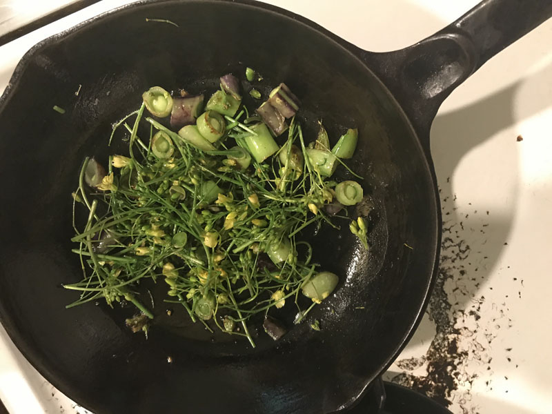 Sauteed arugula bloom stalks and sugar snap peas in cast iron pan, Photo (C) Karen Bussolini